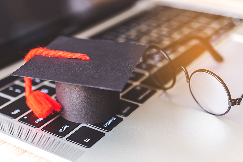 Photo of graduation hat with laptop